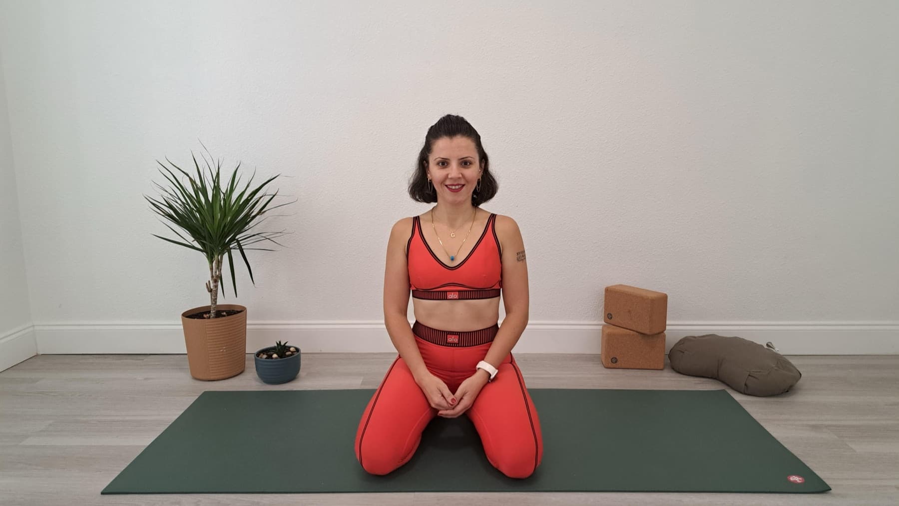Gülçin kneeling on a green mat in her studio